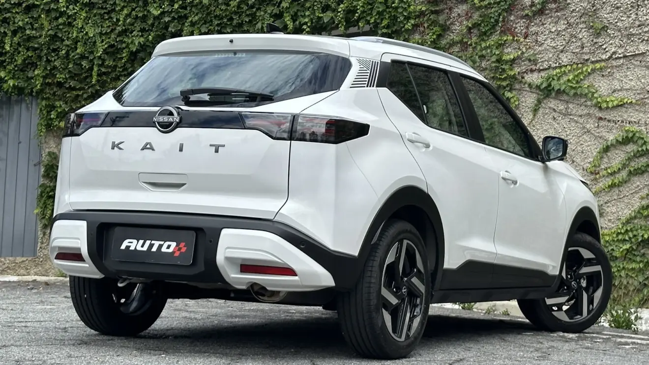 Nissan Kait Exclusive branco parado de traseira com portão cinza e muro de cimento ao fundo