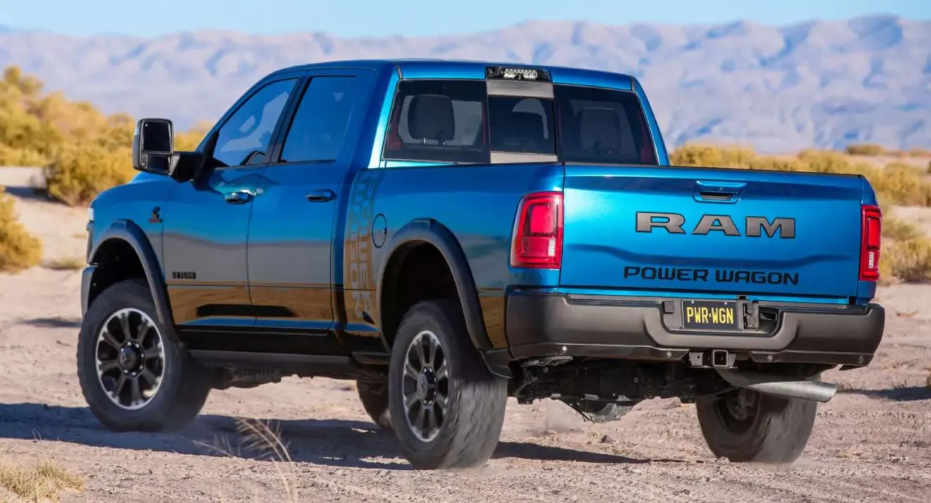 Caminhonete Ram 2500 Power Wagon azul andando na areia de frente