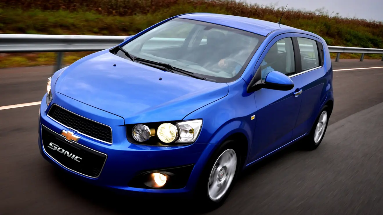 Chevrolet Sonic hatch azul visto de frente e com iluminação acesa