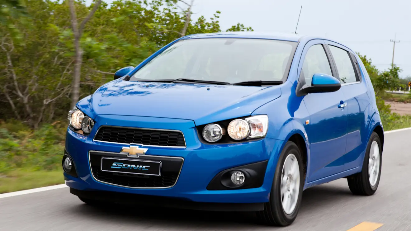 Chevrolet Sonic hatch azul visto de frente e com iluminação acesa