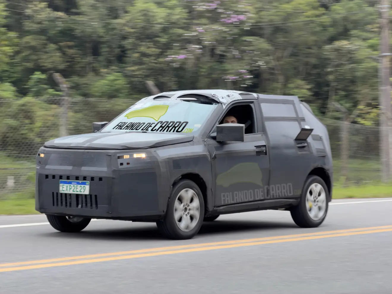 Protótipo camuflado e visto de frente do novo Fiat Argo e com faróis acesos