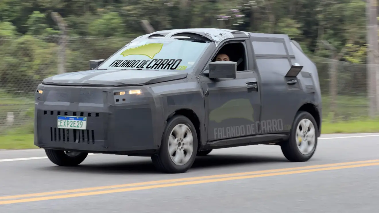 Protótipo camuflado e visto de frente do novo Fiat Argo e com faróis acesos