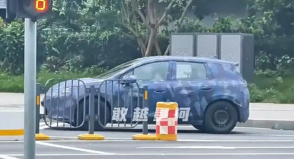 BYD Dolphin Híbrido Plug-In camuflado de lateral andando na cidade