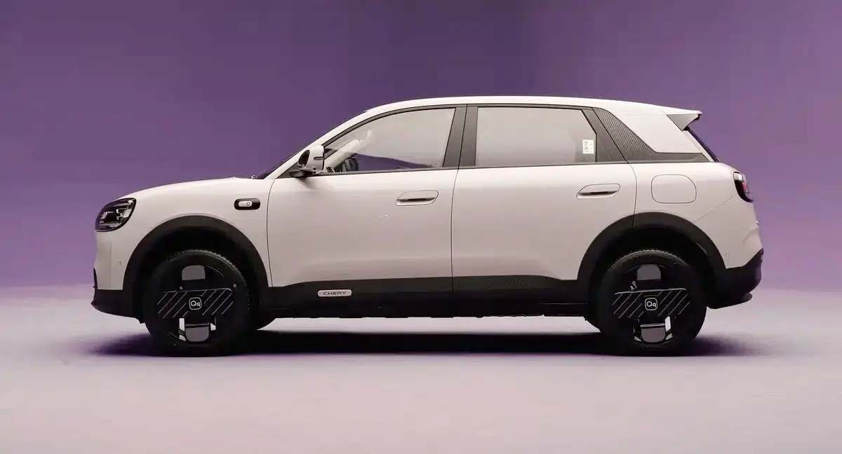 Novo Chery QQ bege parado de lateral com fundo roxo