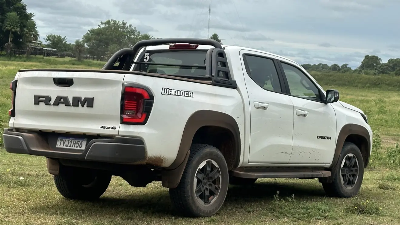 Caminhonete Ram Dakota Warlock branca parada de traseira com árvores ao fundo