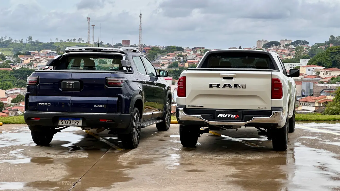Fiat Toro Ranch azul na chuva de traseira ao lado de uma Ram Rampage Big Horn branca
