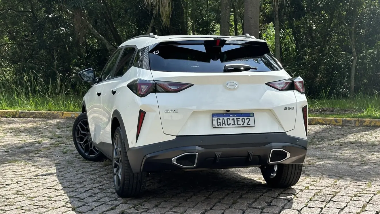 GAC GS3 Elite branco parado de traseira com plantas ao fundo 