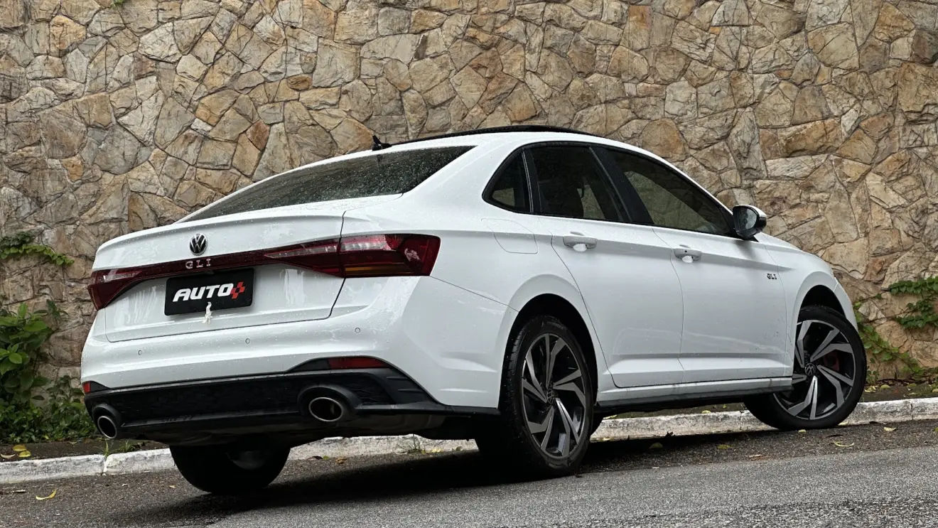 Volkswagen Jetta GLI 350 TSI branco parado de traseira com muro de pedras ao fundo