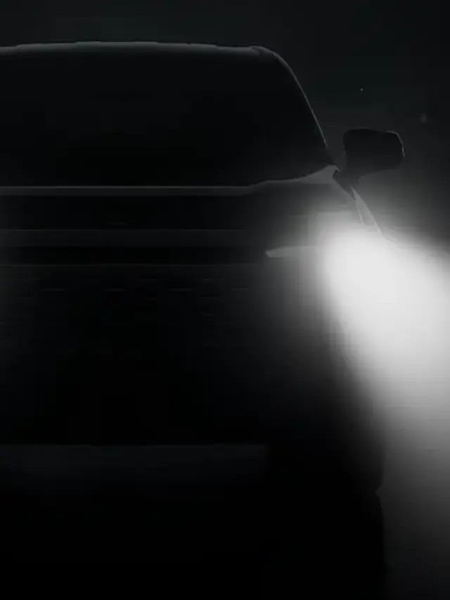 Toyota RAV4 escondido por uma imagem bem escura, aparecendo somente o facho dos faróis