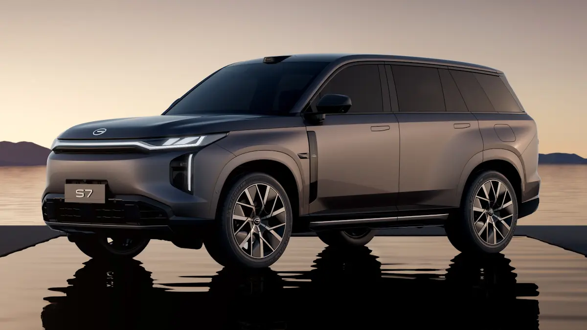 GAC S7 dourado de frente com uma poça d'`agua refletindo ele