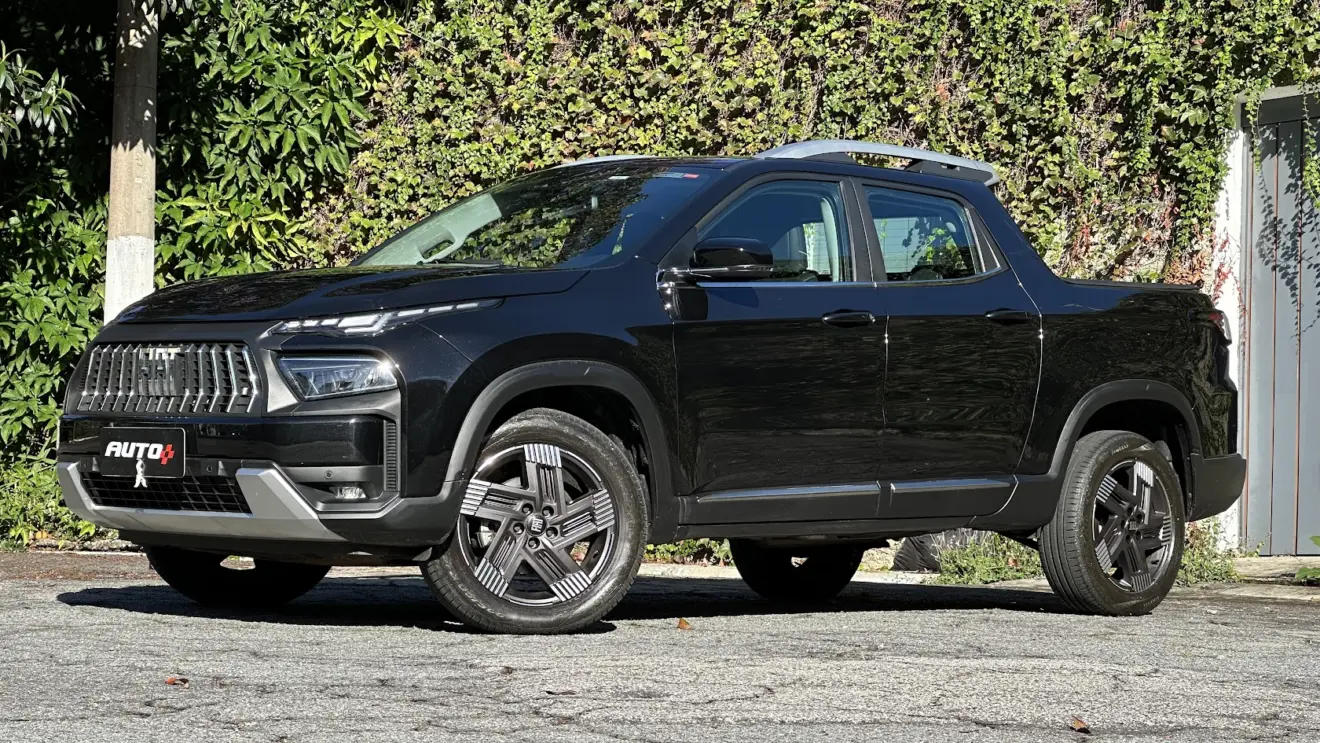 Fiat Toro Volcano Turbo 270 Flex preta parada de frente com muro de plantas ao fundo