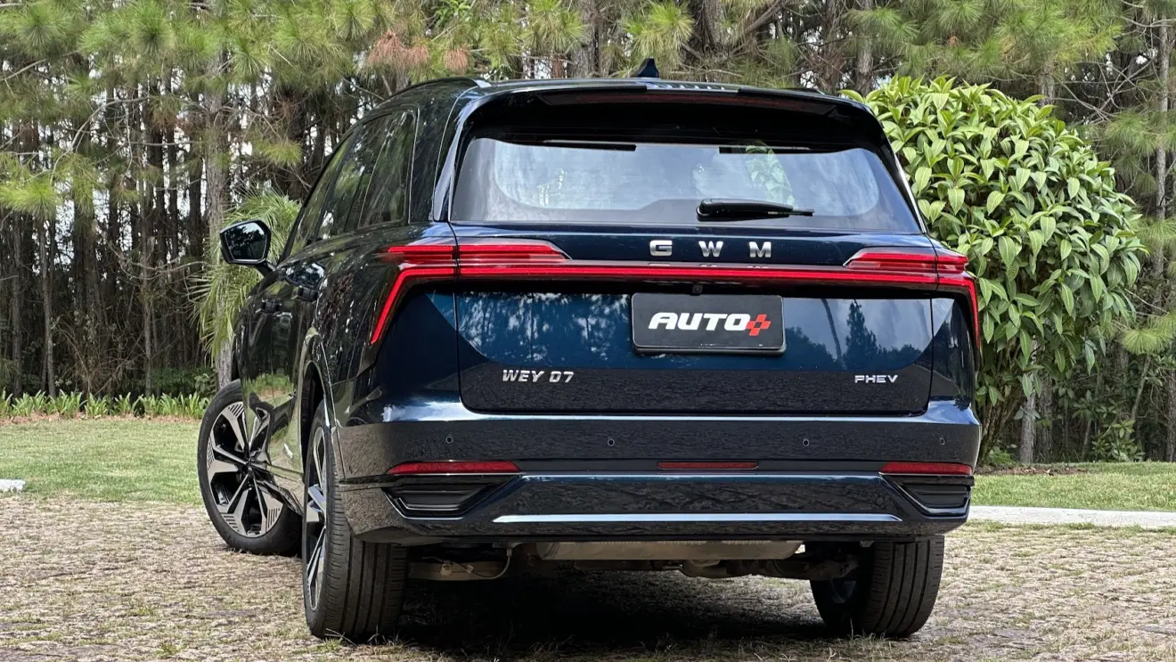 GWM Wey 07 azul parado de traseira com árvores ao fundo