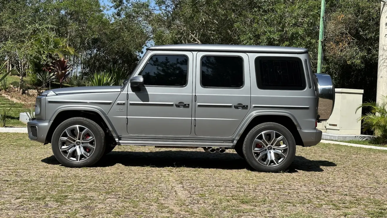 Mercedes-AMG G 63 parado de lateral com árvores ao fundo
