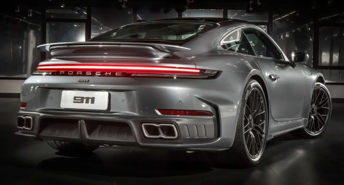 Novo Porsche 911 Turbo S 992.2 cinza parado de traseira