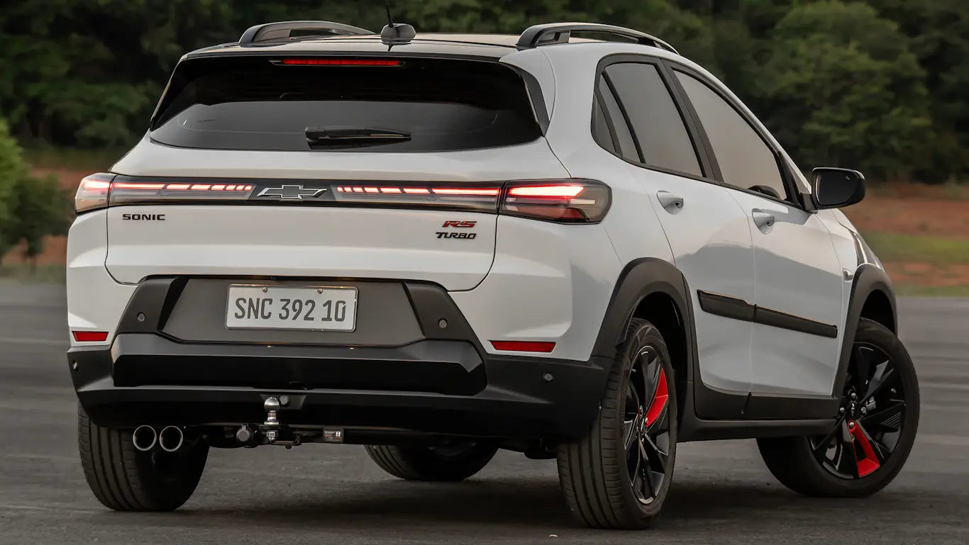 Chevrolet Sonic RS cinza visto de trás e com iluminação acesa