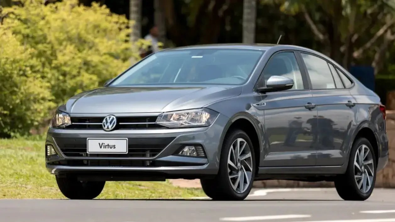 Volkswagen Virtus cinza de frente com plantas ao fundo
