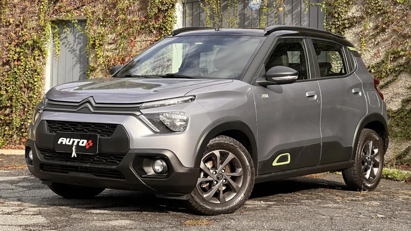 Citroën C3 XTR cinza parado de frente com muro de plantas ao fundo