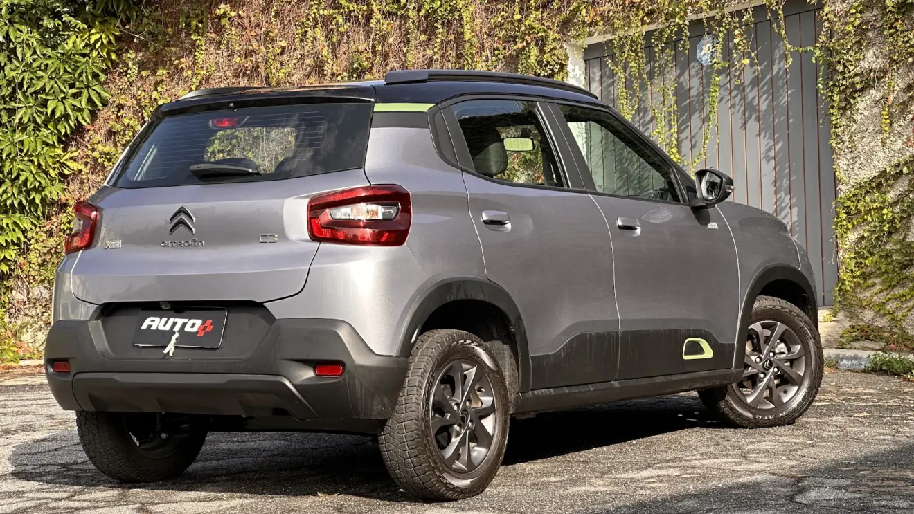 Citroën C3 XTR cinza parado de traseira com portão cinza ao fundo