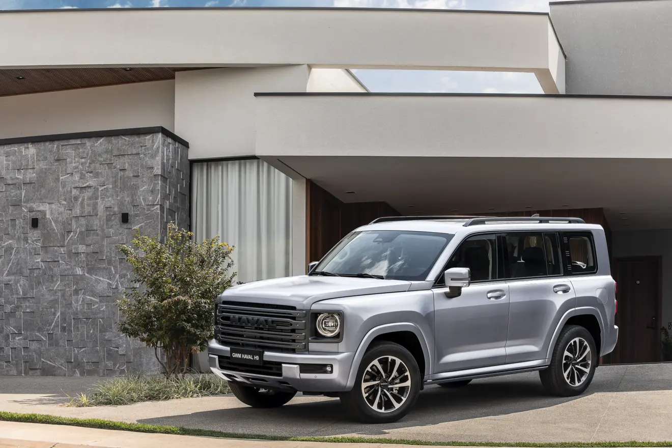GWM Haval H9 prata parado de frente com casa ao fundo