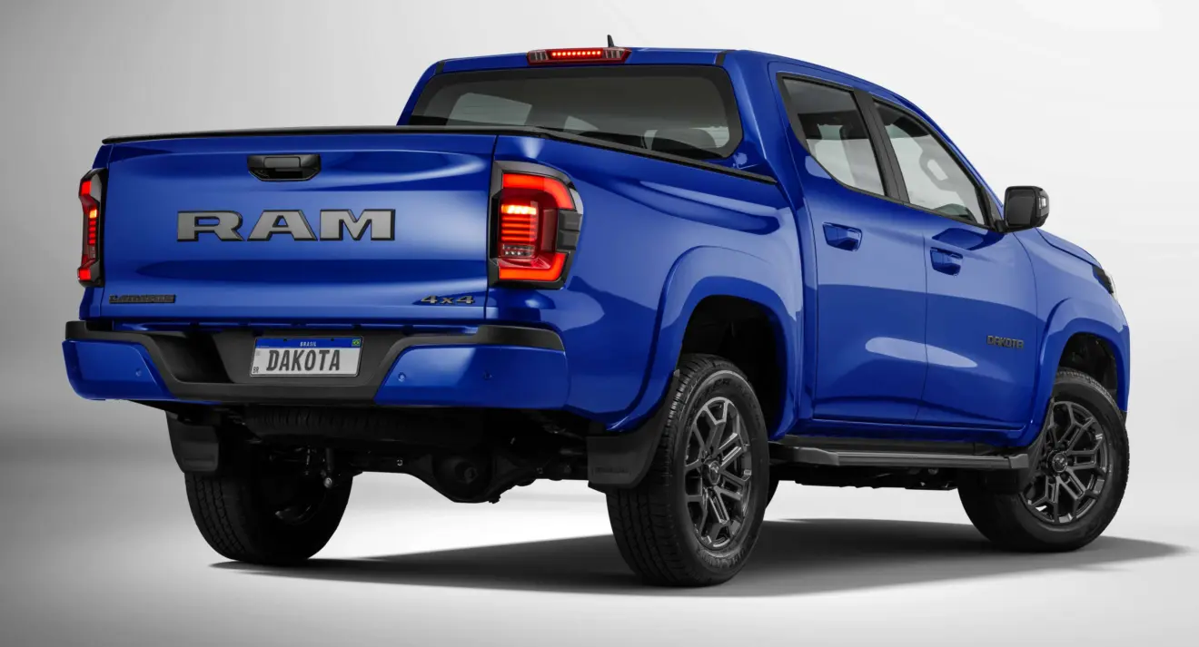 Caminhonete Ram Dakota Laramie Night Edition parada de traseira com fundo branco