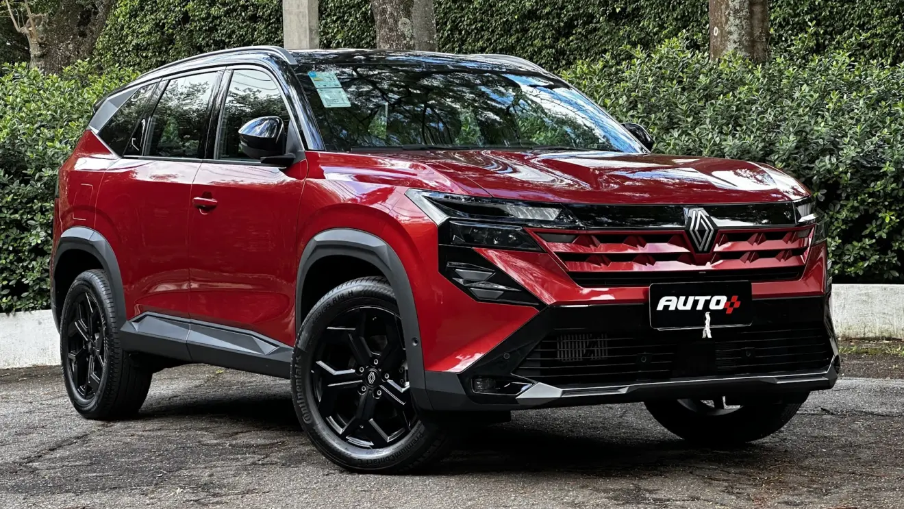 Renault Boreal Techno vermelho parado de lateral com árvores ao fundo