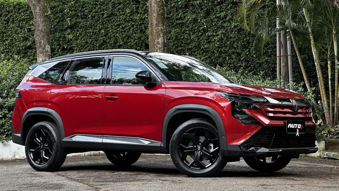 Renault Boreal Techno vermelho parado de lateral com árvores ao fundo