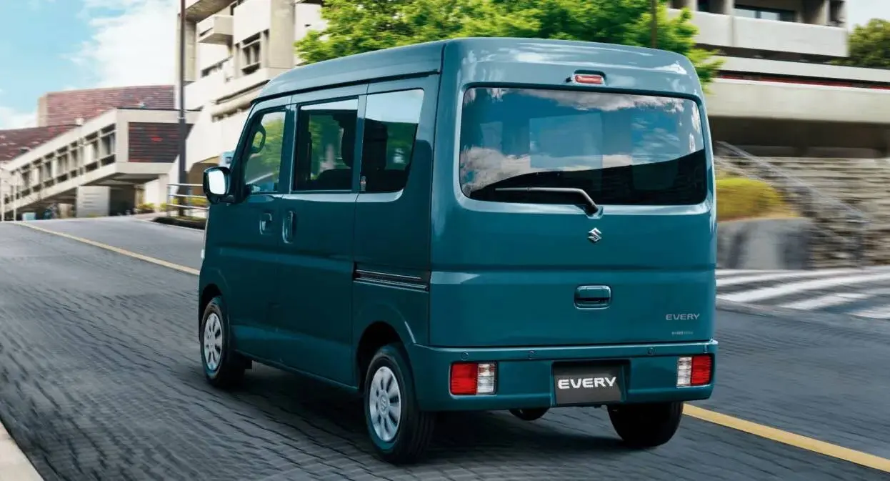 Suzuki Every verde de traseira andando na cidade