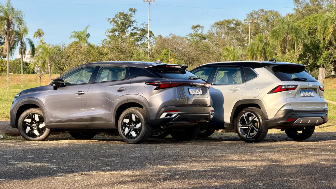 Omoda 5 Prestige cinza de traseira ao lado de um Toyota Yaris Cross XRX Hybrid prata