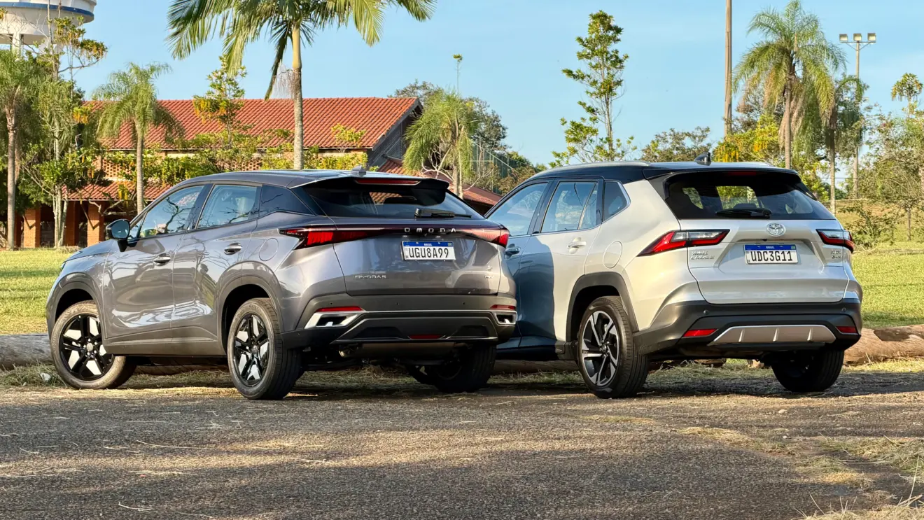 Omoda 5 Prestige cinza de traseira ao lado de um Toyota Yaris Cross XRX Hybrid prata