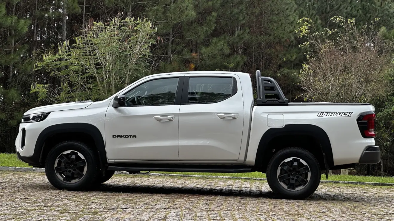 Picape Ram Dakota Warlock branca parada de lateral com árvores ao fundo 