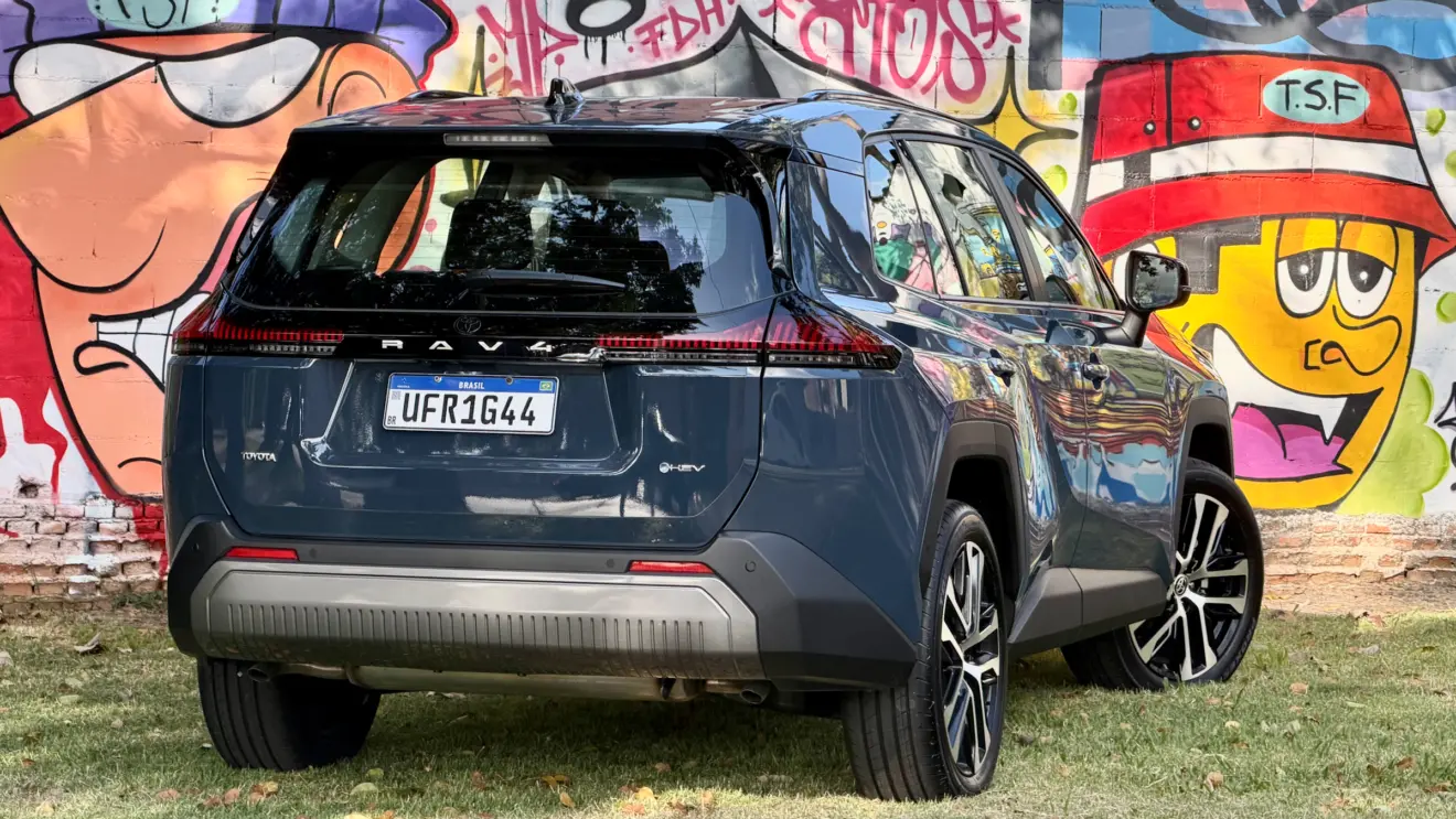 Toyota RAV4 azul de traseira com um muro com grafitti atrás