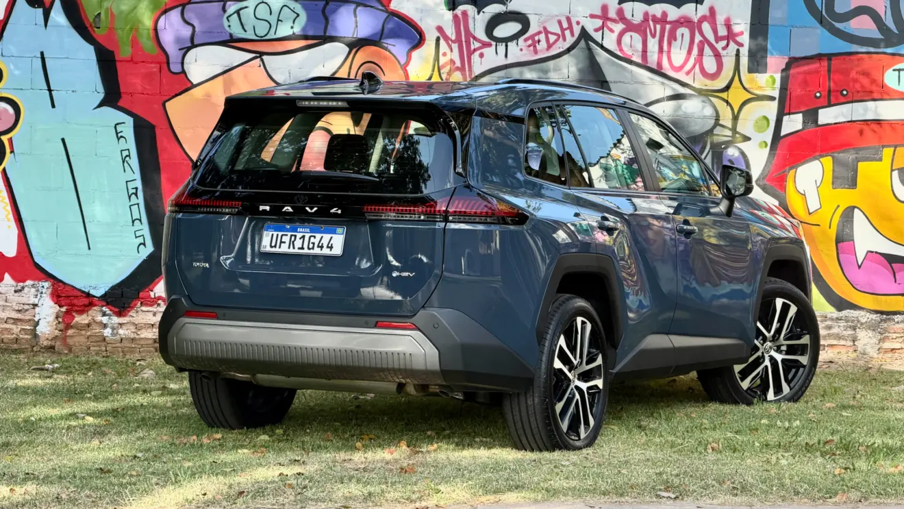 Toyota RAV4 azul de traseira com um muro com grafitti atrás