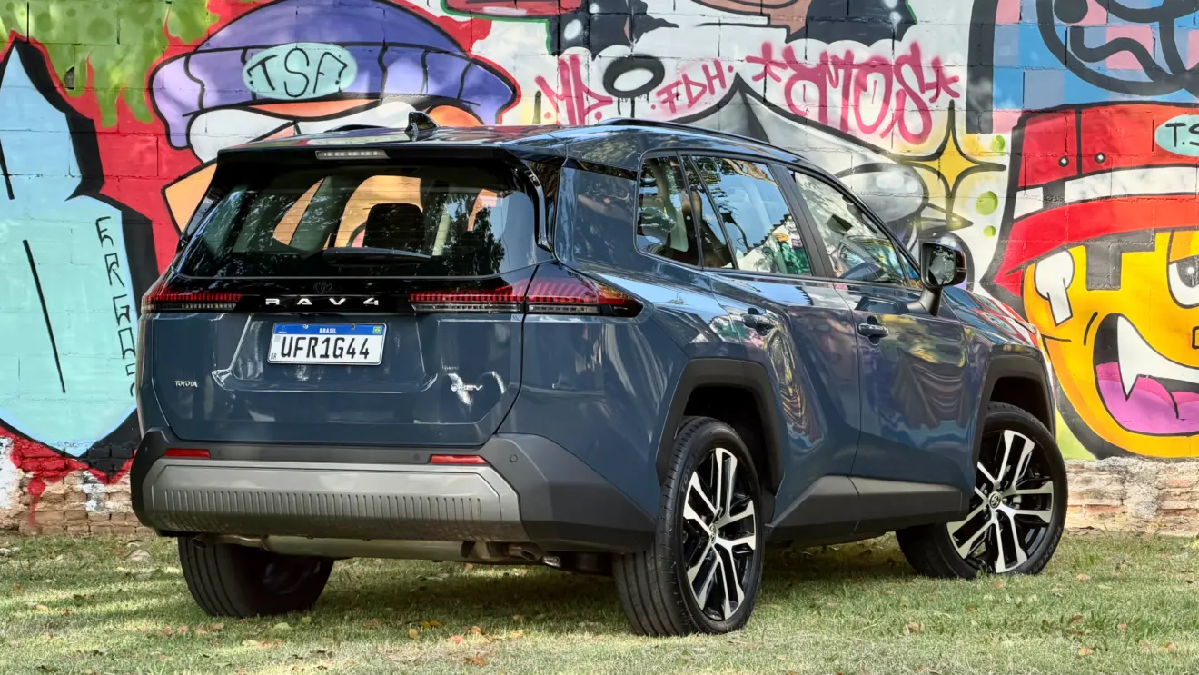Toyota RAV4 azul de traseira com um muro com grafitti atrás