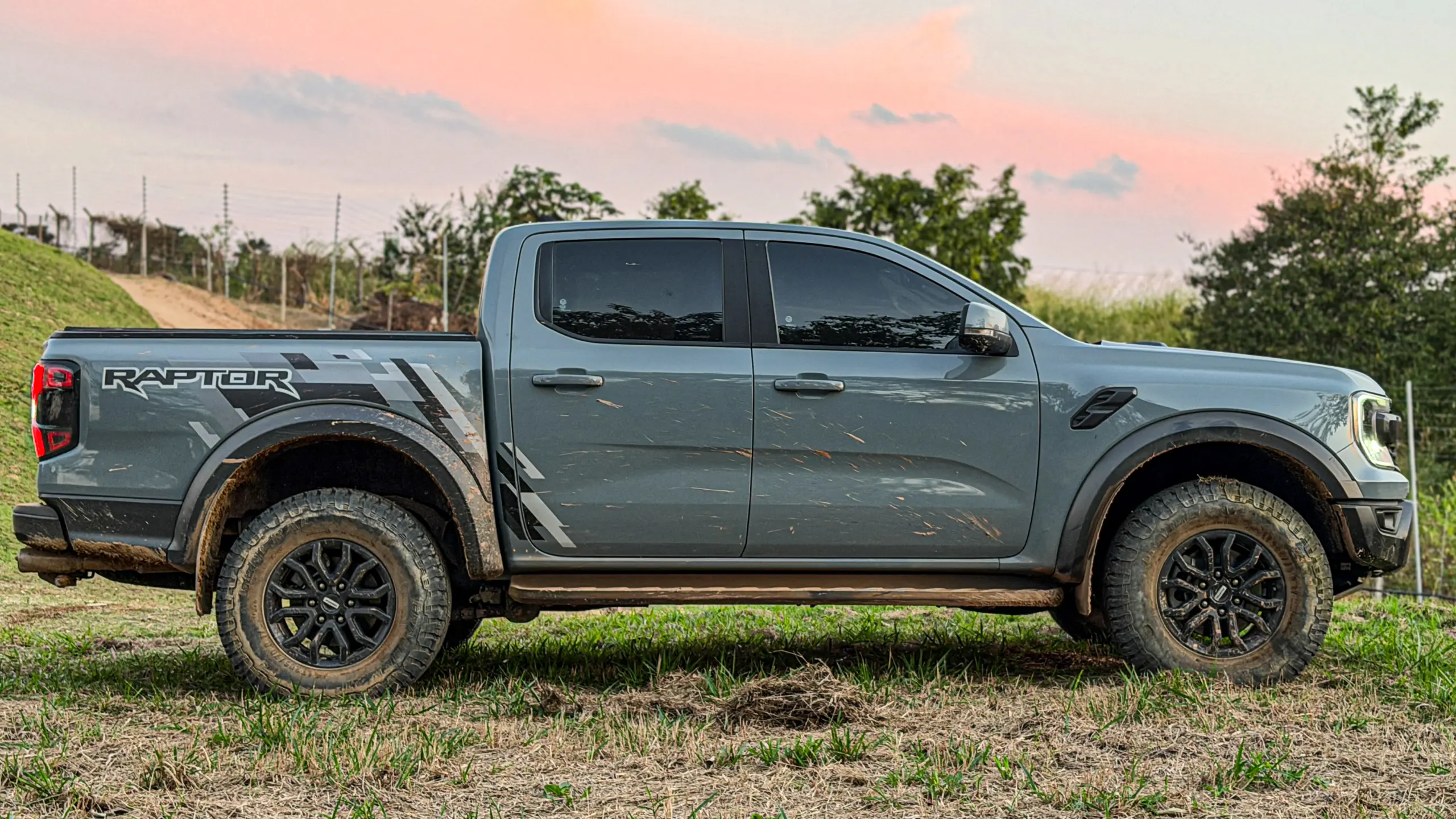 Ford Ranger Raptor suja de barro e terra estática na grama na cor Cinza Interlagos
