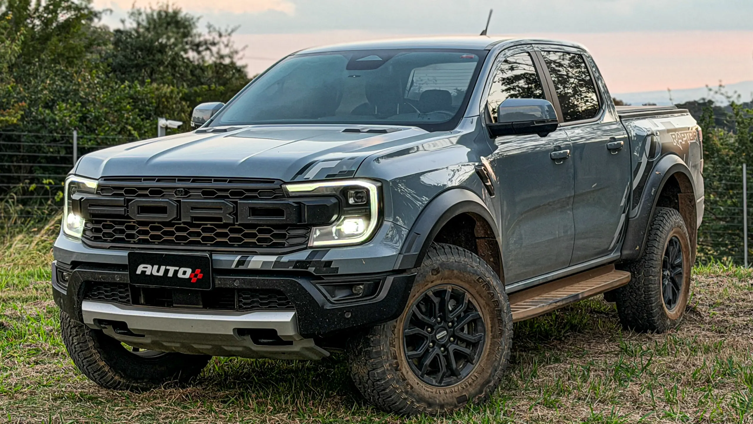 Ford Ranger Raptor suja de barro e terra estática na grama na cor Cinza Interlagos