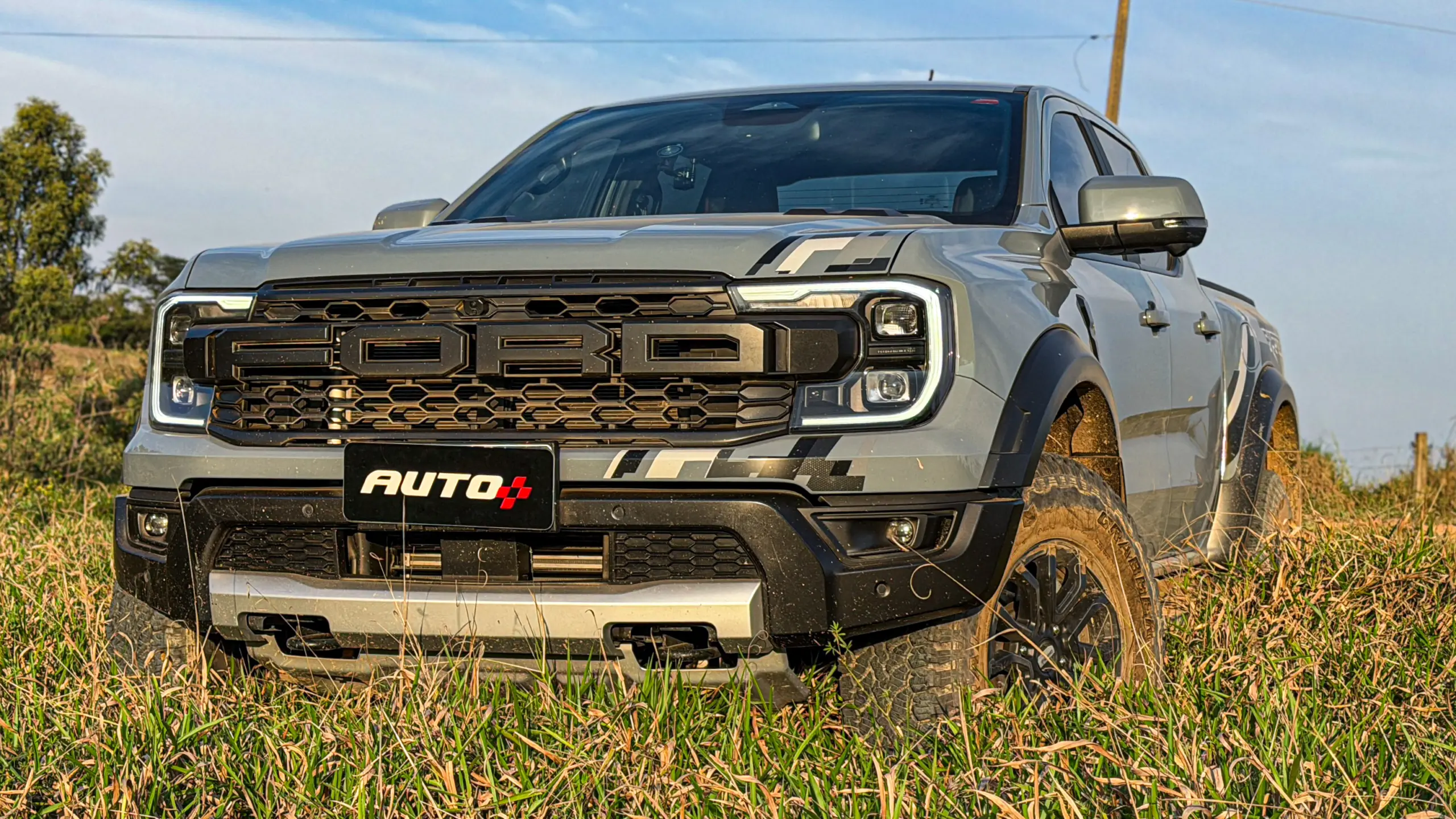 Ford Ranger Raptor suja de barro e terra estática na grama na cor Cinza Interlagos