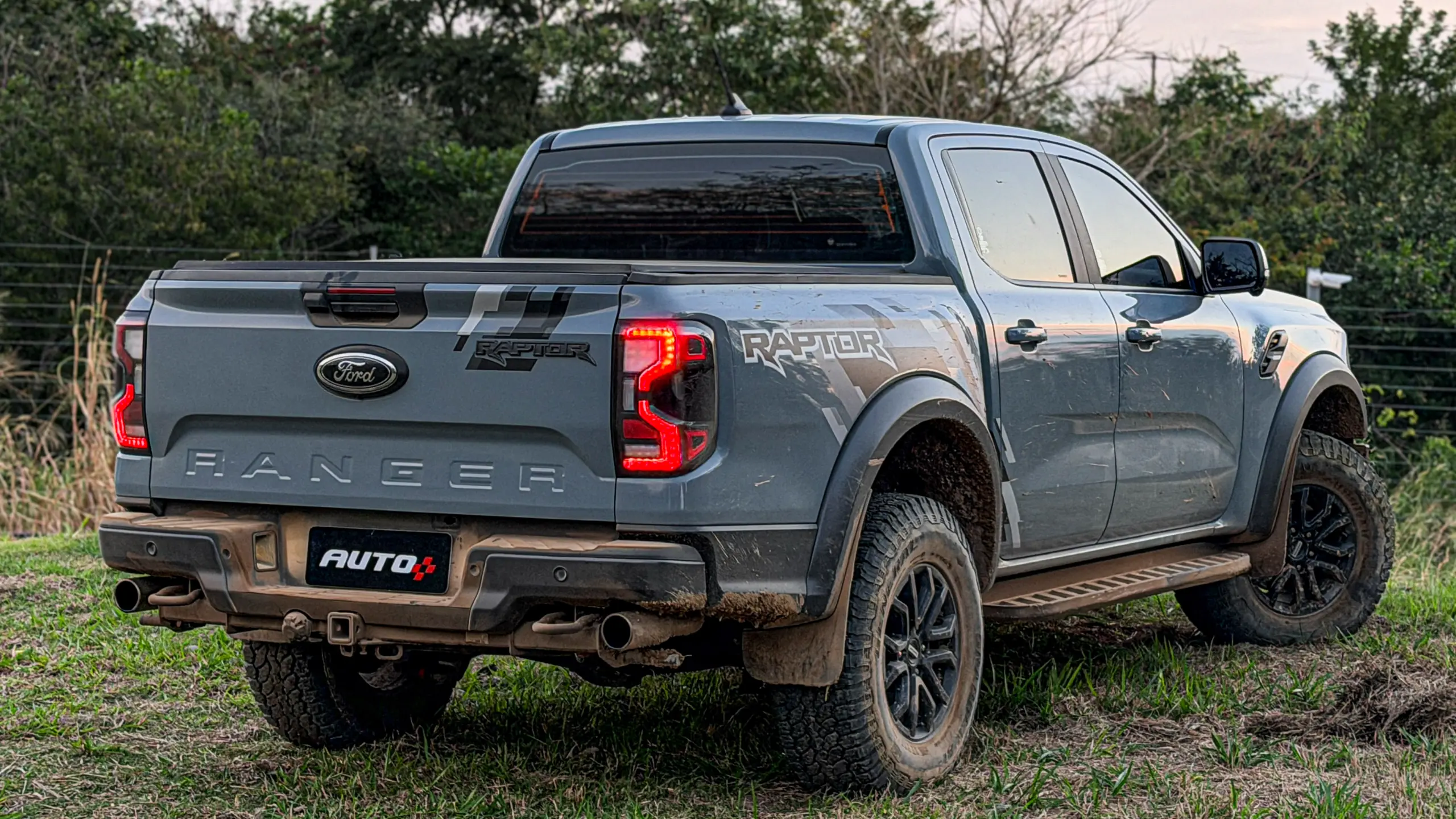 Ford Ranger Raptor suja de barro e terra estática na grama na cor Cinza Interlagos