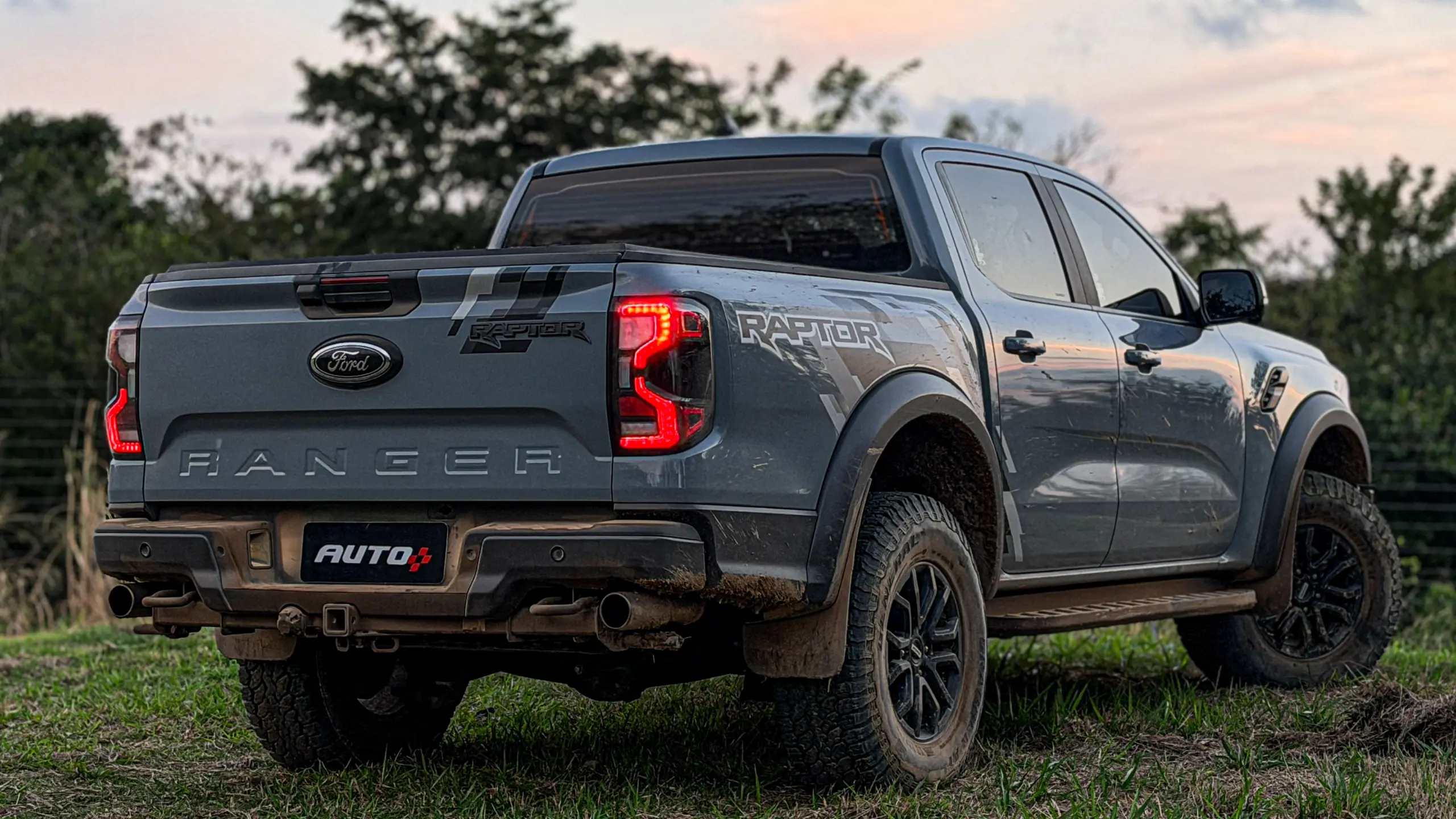 Ford Ranger Raptor suja de barro e terra estática na grama na cor Cinza Interlagos