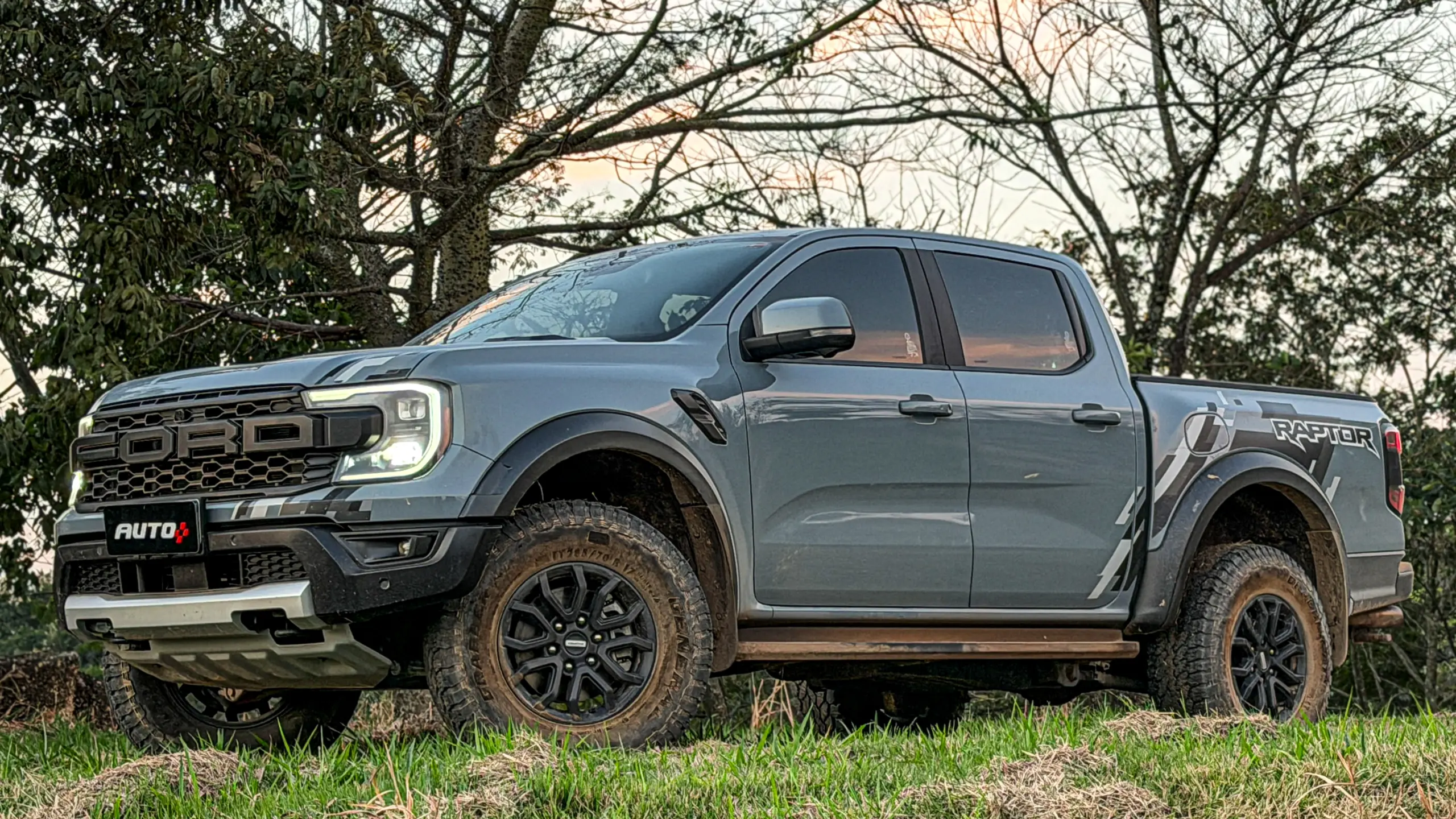 Ford Ranger Raptor suja de barro e terra estática na grama na cor Cinza Interlagos