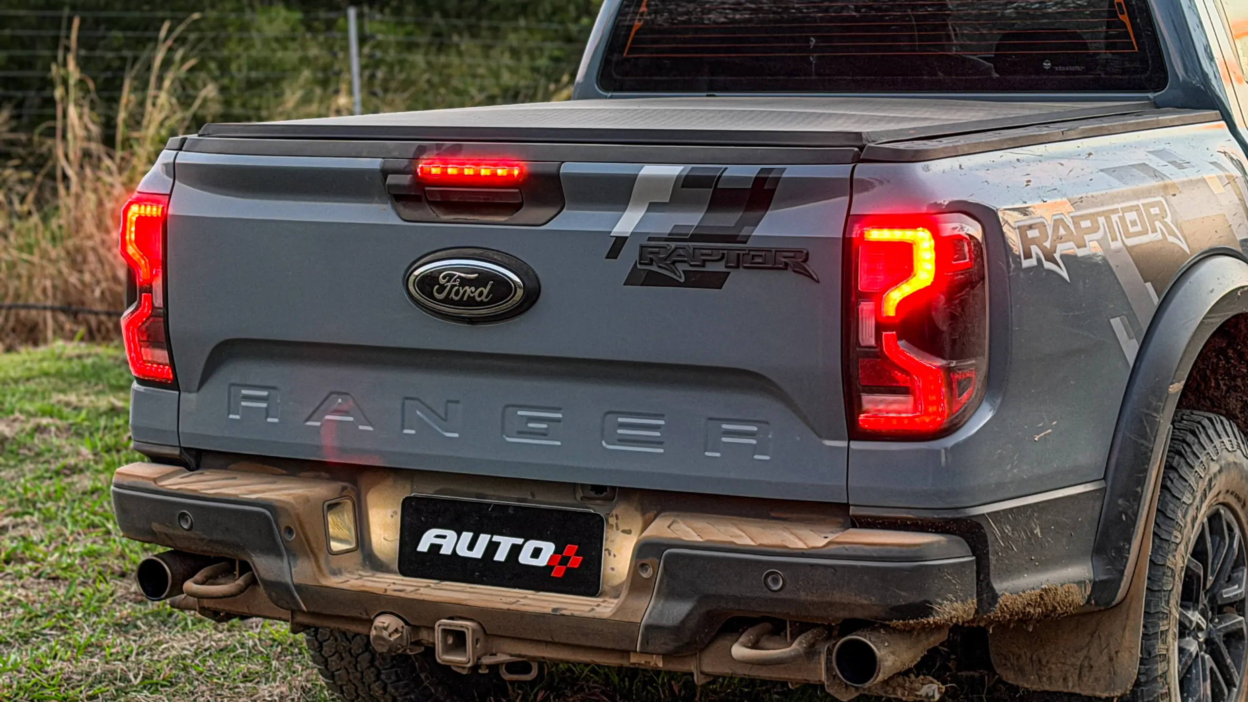 Ford Ranger Raptor suja de barro e terra estática na grama na cor Cinza Interlagos