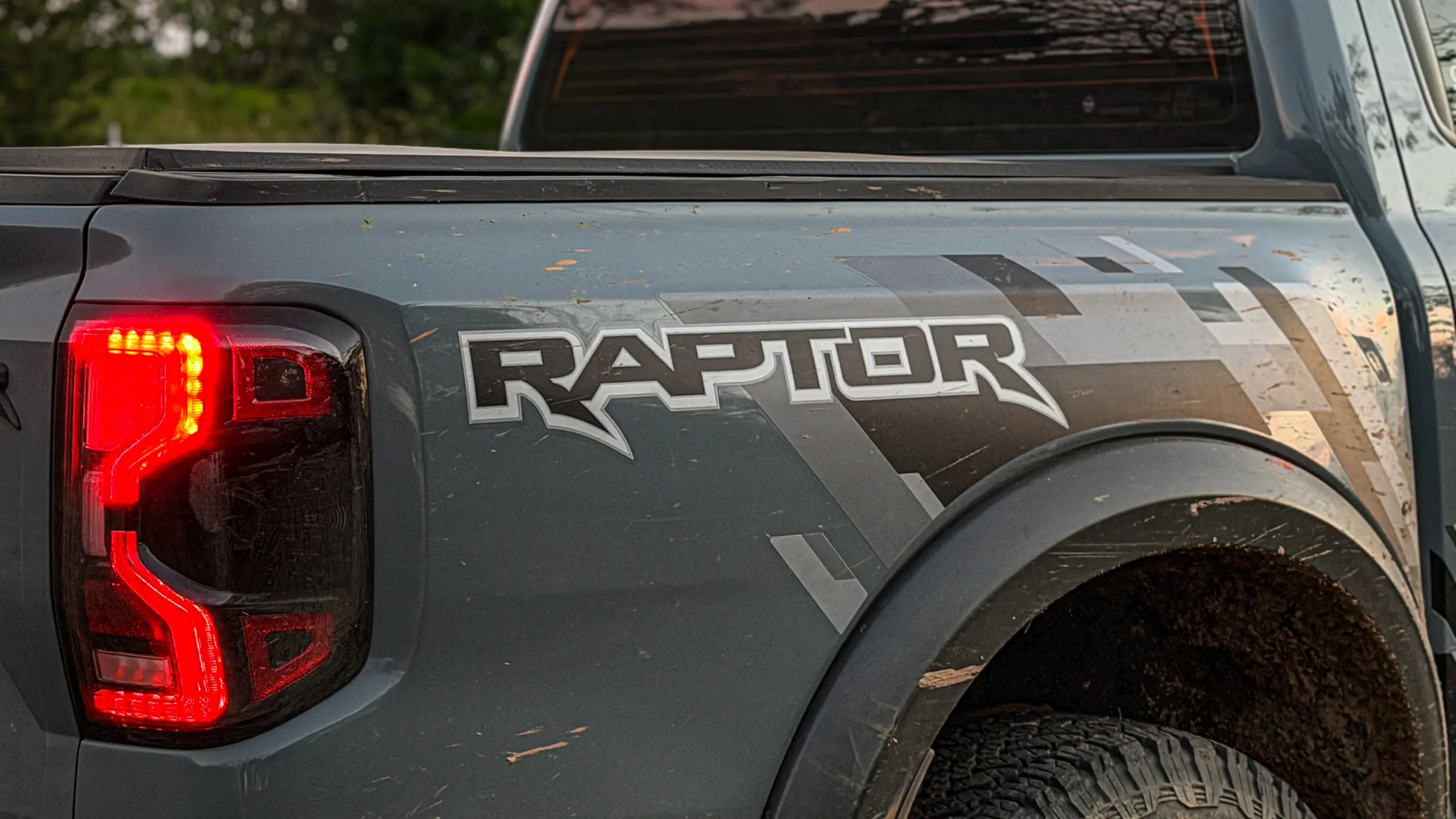 Ford Ranger Raptor suja de barro e terra estática na grama na cor Cinza Interlagos