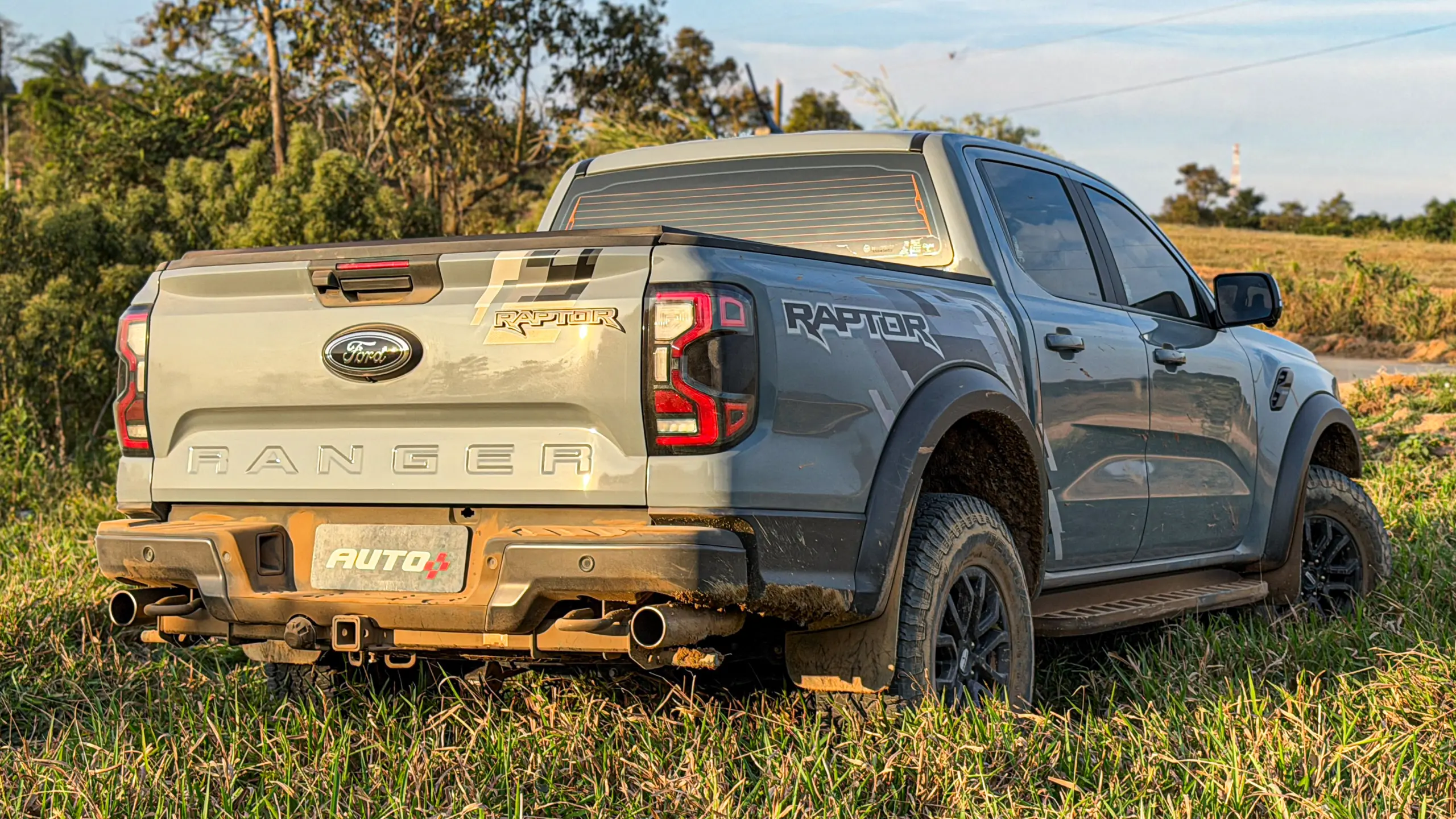 Ford Ranger Raptor suja de barro e terra estática na grama na cor Cinza Interlagos