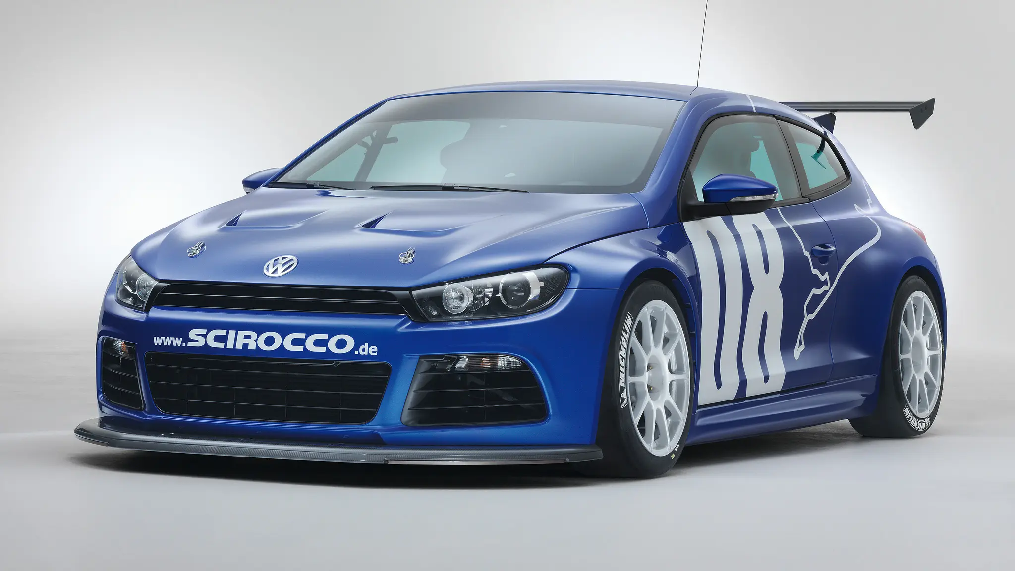 Volkswagen Scirocco GT24 azul parado de frente com fundo neutro