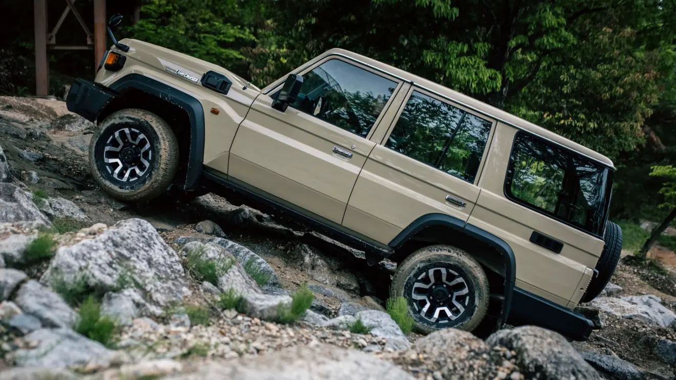 Toyota Land Cruiser 70 bege de lado subindo predras