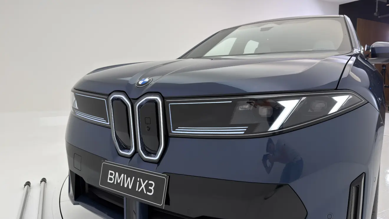 BMW iX3 azul estático com fundo branco