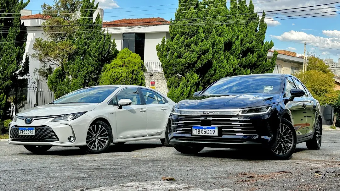 Comparativo BYD King GS e Toyota Corolla Altis Premium branco com casa ao fundo