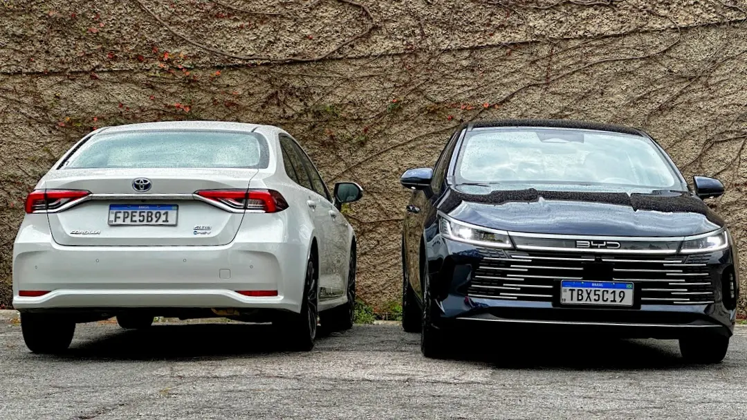 BYD King GS azul e Toyota Corolla Altis Premium branco parados um ao lado do outro