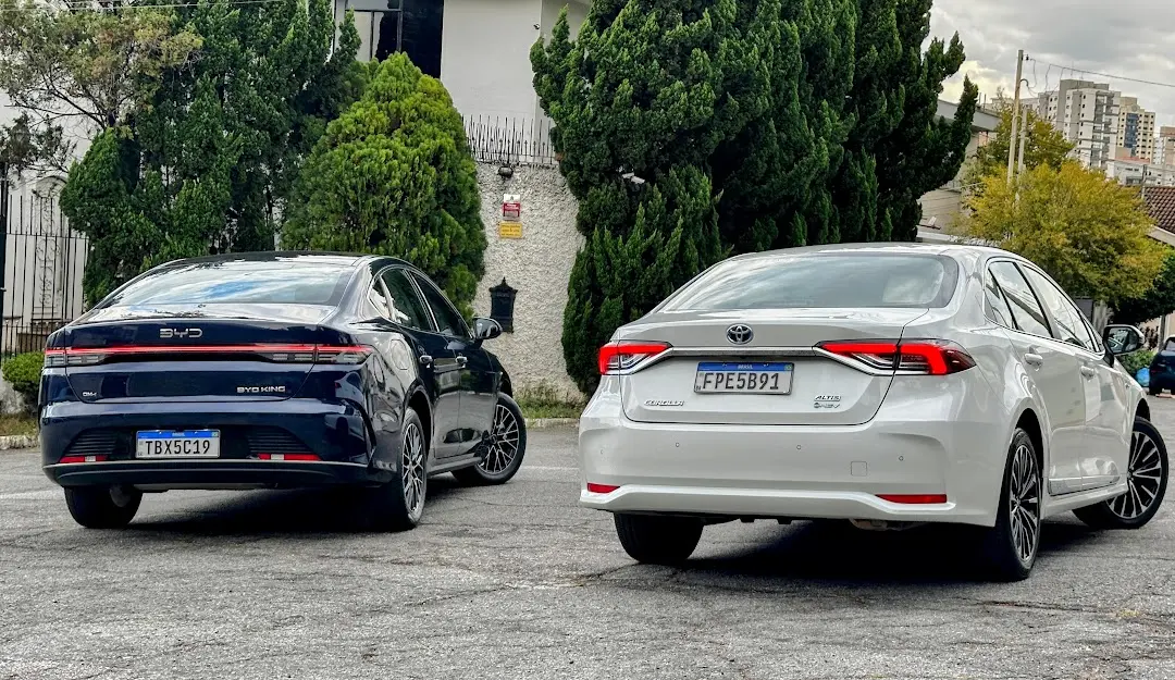 Toyota Corolla Altis Premium branco e BYD King GS Azul de traseira