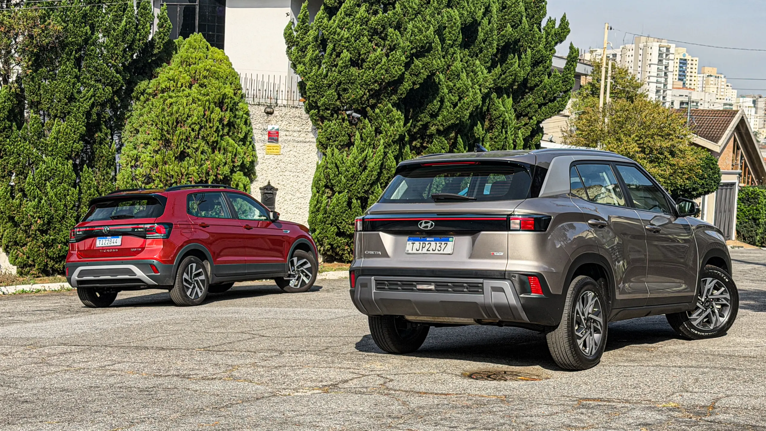 Volkswagen T-Cross Comfortiline Vermelho Sunset ao lado do Hyundai Creta Limited (na cor Cinza Silk estático