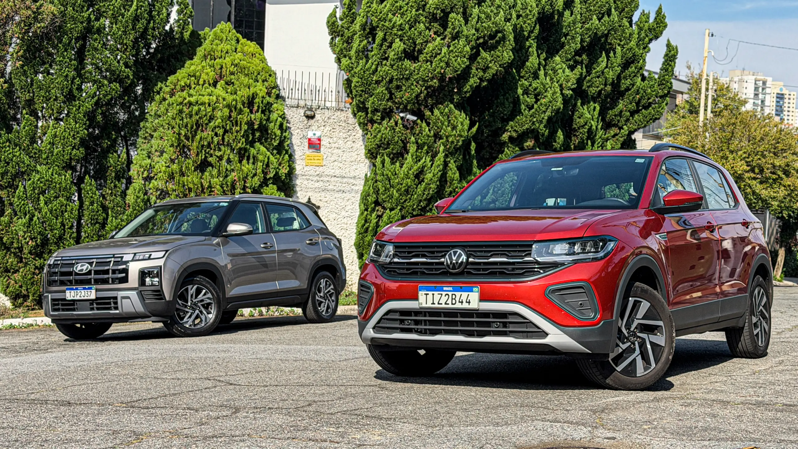 Volkswagen T-Cross Comfortiline Vermelho Sunset ao lado do Hyundai Creta Limited (na cor Cinza Silk estático